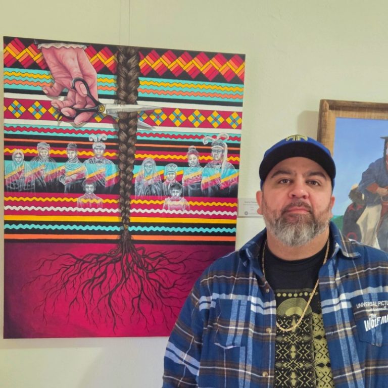 Jeremy Thompson stands beside his painting depicting a braid being cut, with patterned bands and layered figures referencing family history, cultural disruption, and identity.
